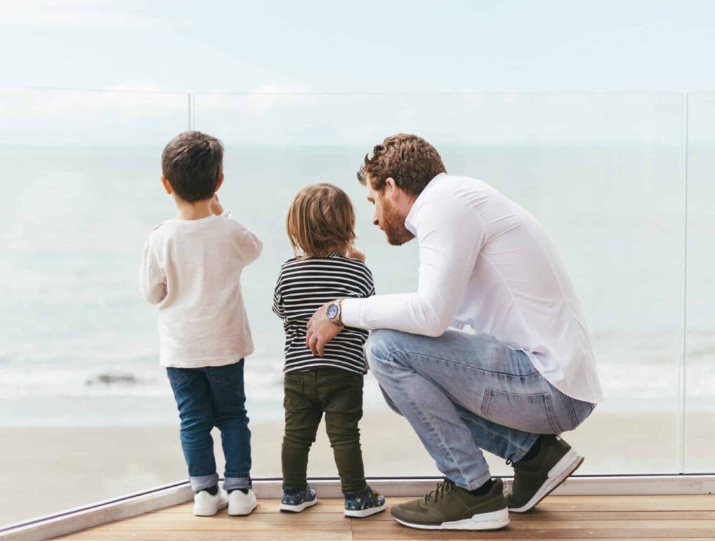 father-with-sons-looking-sea