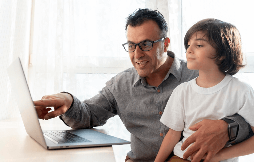 Father and son playing something on a laptop