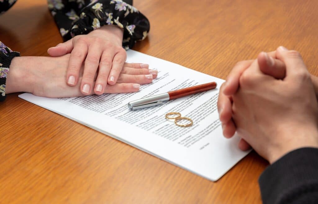 Hands reviewing and signing a divorce affidavit document in Australia, representing legal separation and marriage dissolution.