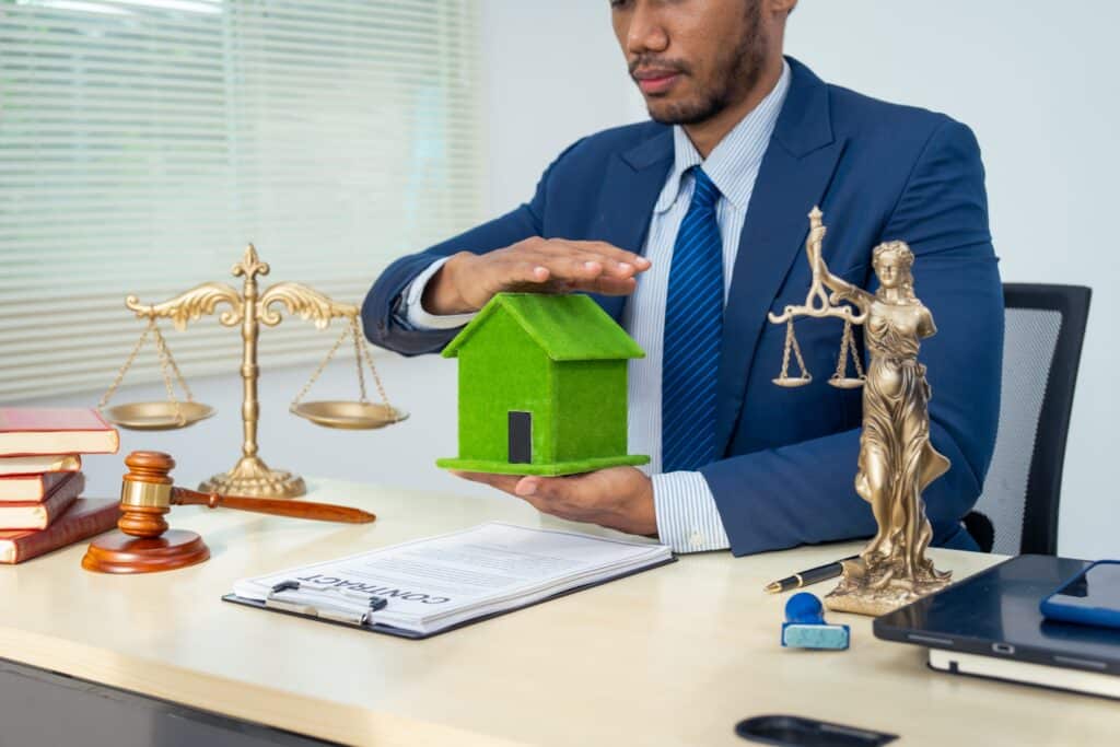 businessman in a formal suit works alone at a family lawyers desk, with golden scales, law books