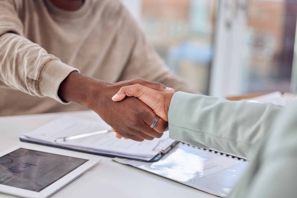 Cropped shot of two businesspeople shaking hands in an office.