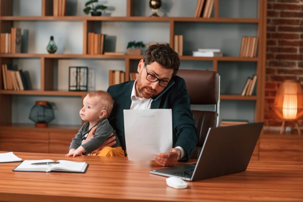 Busy father application for consent orders. Businessman in formal clothes is working indoors. With toddler consent orders