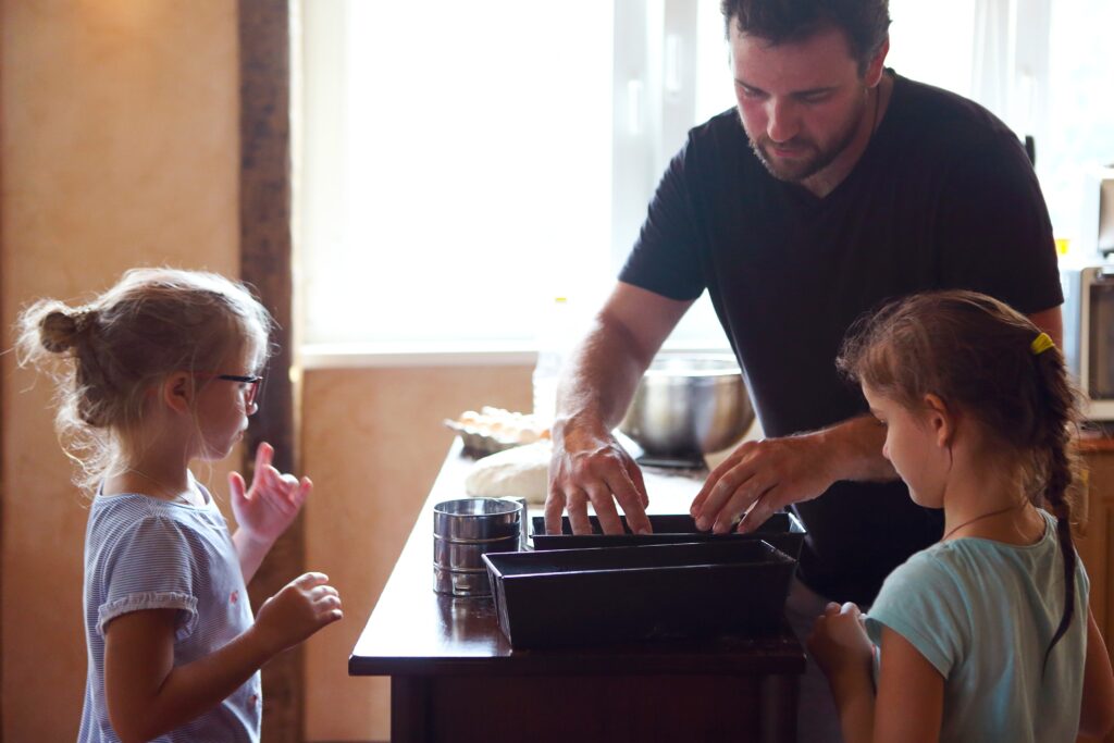 Children cooking homemade bread with there father