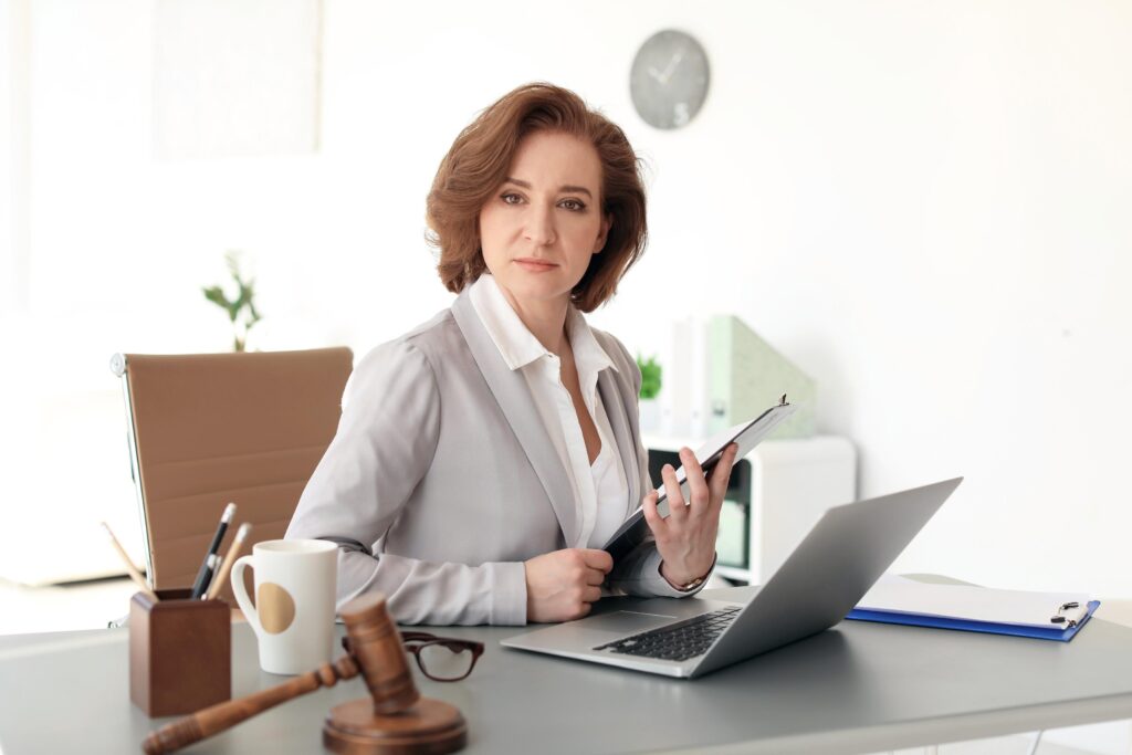 Female lawyer working with laptop at table in office