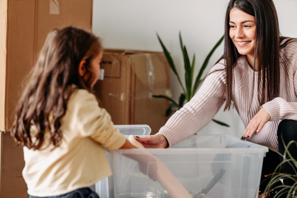 Woman and Child Unpacking Belongings from Moving Box