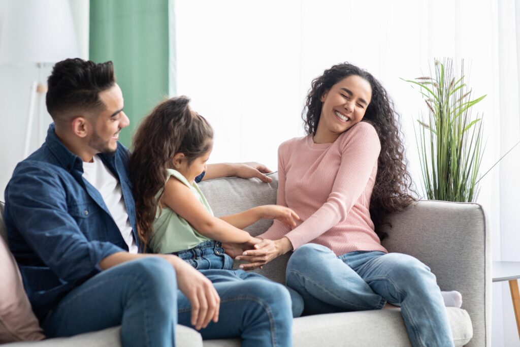 Joyful Young Family Of Three Having Fun At Home