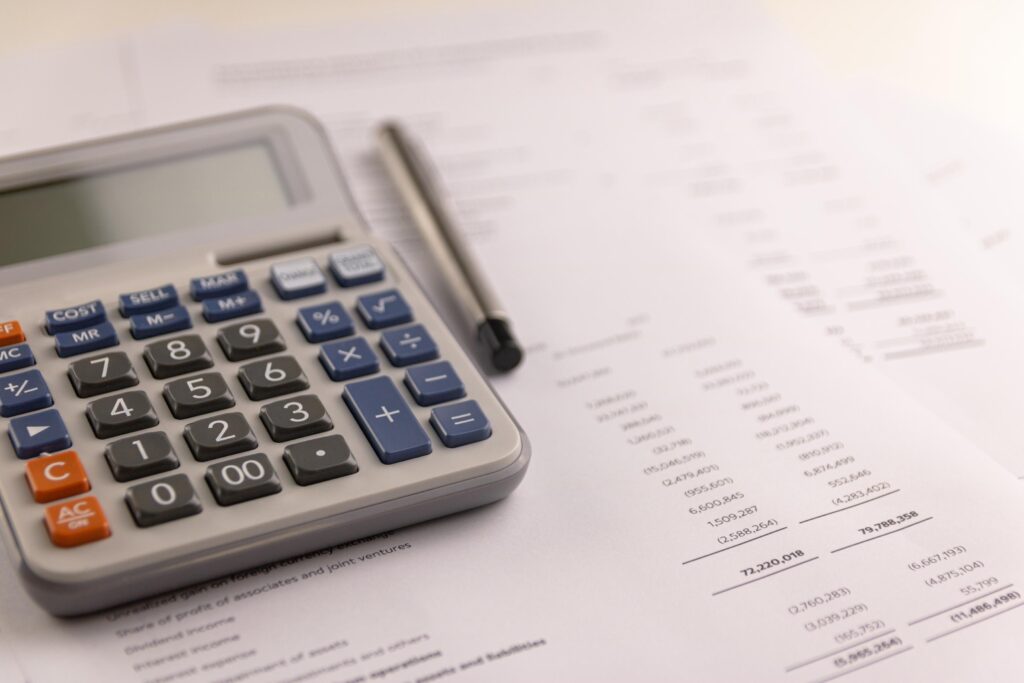 Calculator and pen Placed on accounting documents. Select focus Calculator button. Financial business concept