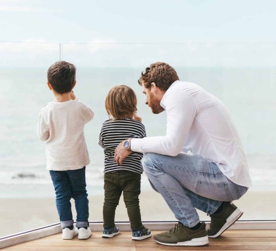 father-with-sons-looking-sea